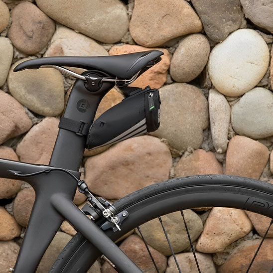 Sacoche de selle velo avec mur pierre derriere